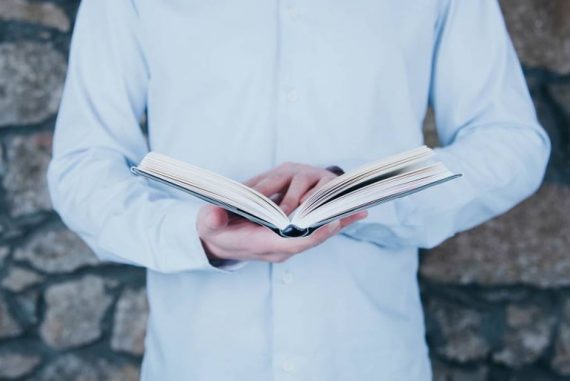 homme debout lisant un livre